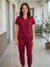 Berry scrub set worn by a healthcare worker